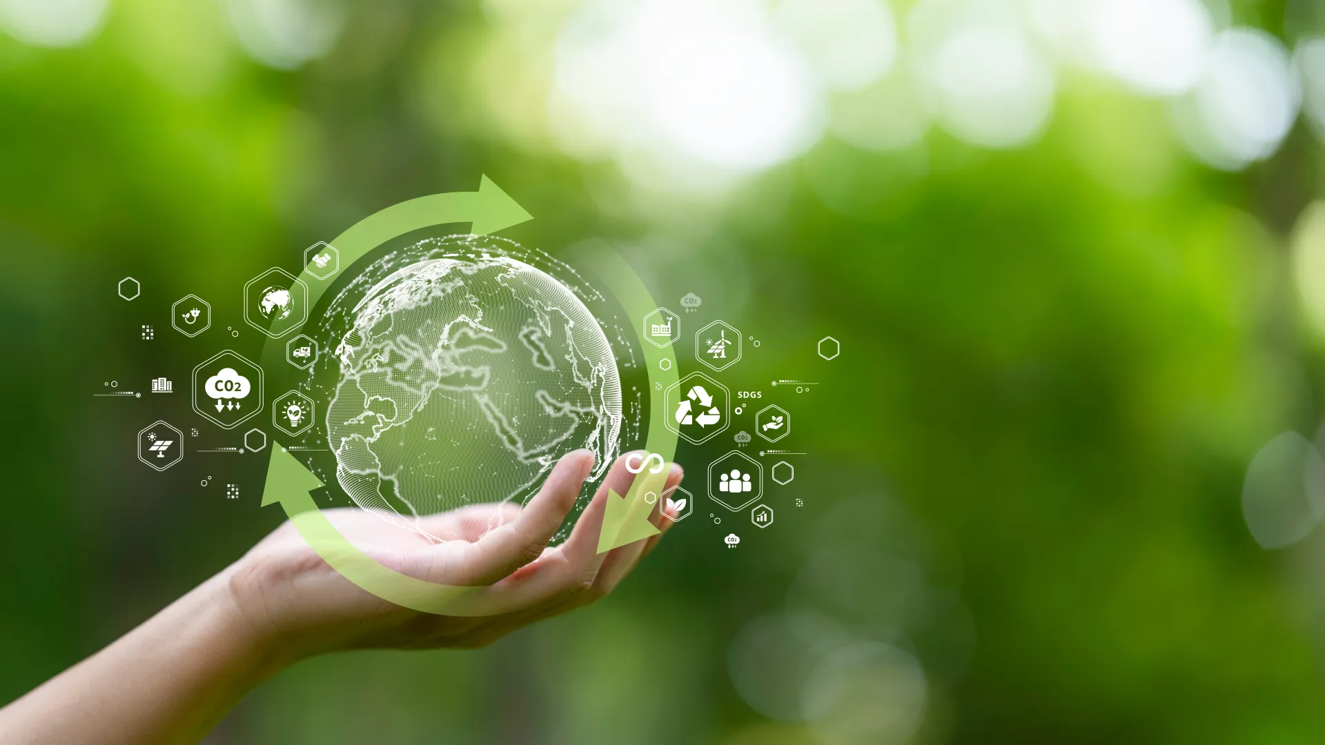 Vor grünem Hintergrund hält eine menschliche Hand eine kleine grüne Erdkugel, um die herum Recyling- und andere Kreislaufwirtschaftssymbole schweben